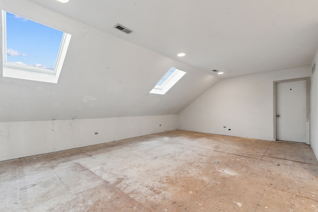 additional living space featuring lofted ceiling with skylight and a healthy amount of sunlight