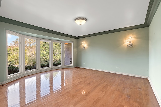 unfurnished room featuring ornamental molding and light wood-type flooring