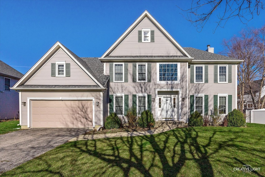 view of front of home with a front yard and a garage