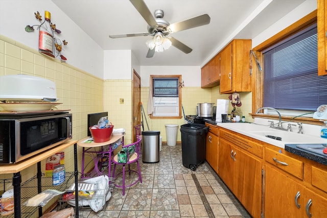 kitchen with tile walls, sink, and ceiling fan