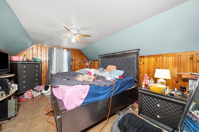 bedroom with lofted ceiling, wooden walls, and ceiling fan