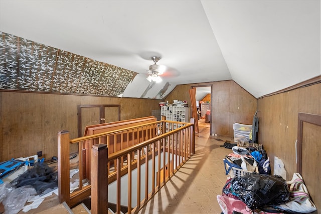 bonus room featuring lofted ceiling, ceiling fan, and wood walls