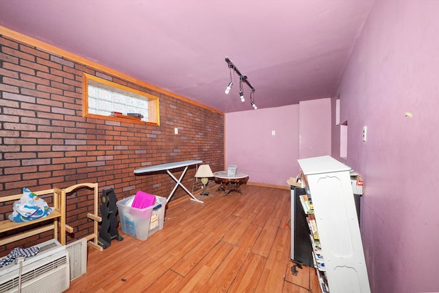 interior space with light hardwood / wood-style floors and brick wall