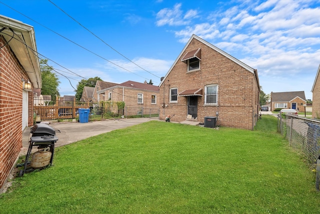 back of property featuring cooling unit and a yard