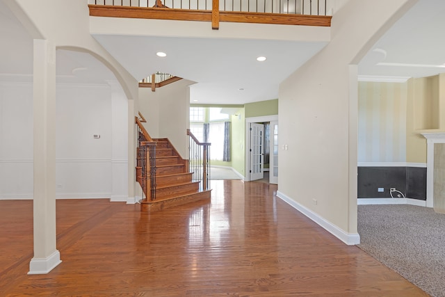 entryway with hardwood / wood-style flooring and crown molding