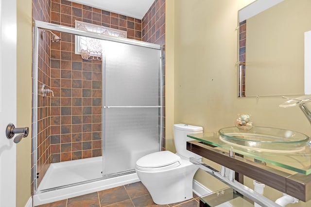 bathroom with toilet, an enclosed shower, and tile patterned floors