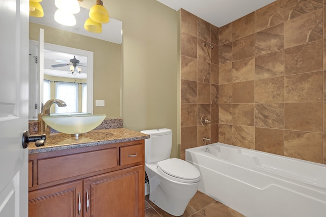 full bathroom with ceiling fan, vanity, tiled shower / bath combo, tile patterned floors, and toilet