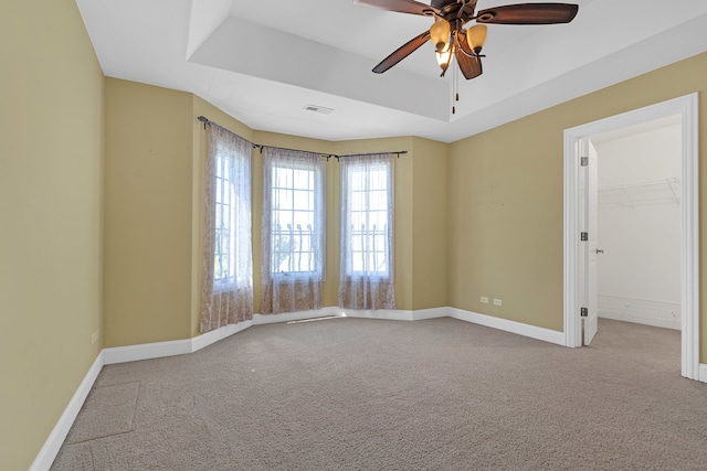 spare room with ceiling fan, carpet floors, and a raised ceiling