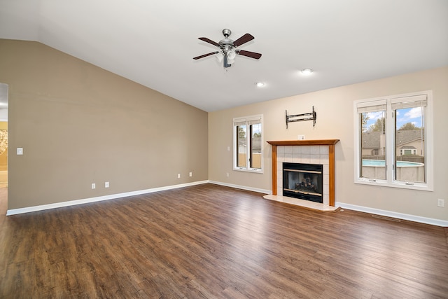 unfurnished living room with a fireplace, vaulted ceiling, ceiling fan, and dark wood-type flooring