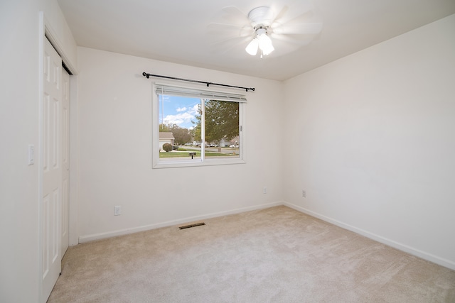 interior space featuring ceiling fan, a closet, and light carpet