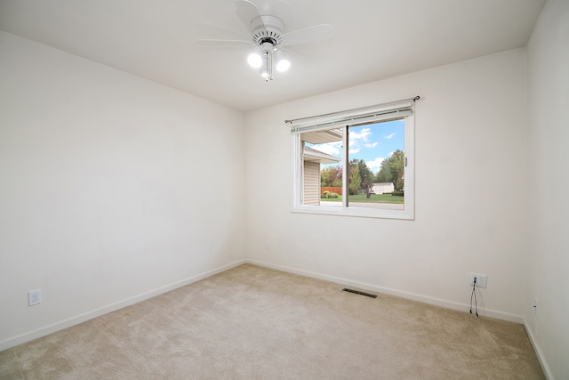 spare room with ceiling fan and light colored carpet