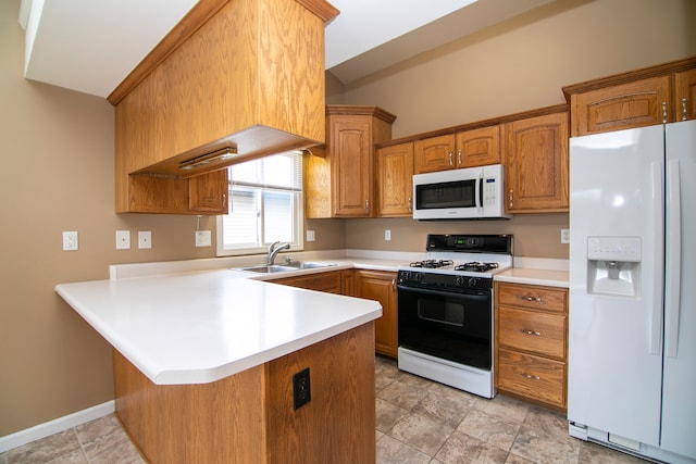 kitchen with kitchen peninsula, sink, and white appliances