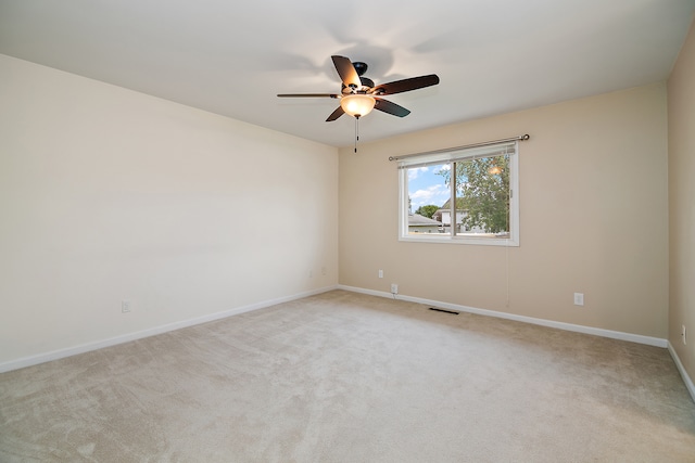 spare room with ceiling fan and light colored carpet