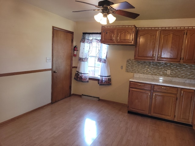 kitchen featuring ceiling fan, light hardwood / wood-style floors, and tasteful backsplash