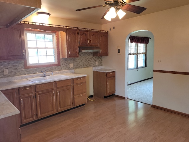 kitchen with ceiling fan, light hardwood / wood-style flooring, sink, and decorative backsplash