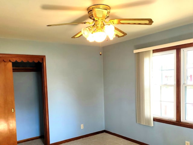 unfurnished bedroom with ceiling fan, a closet, and multiple windows