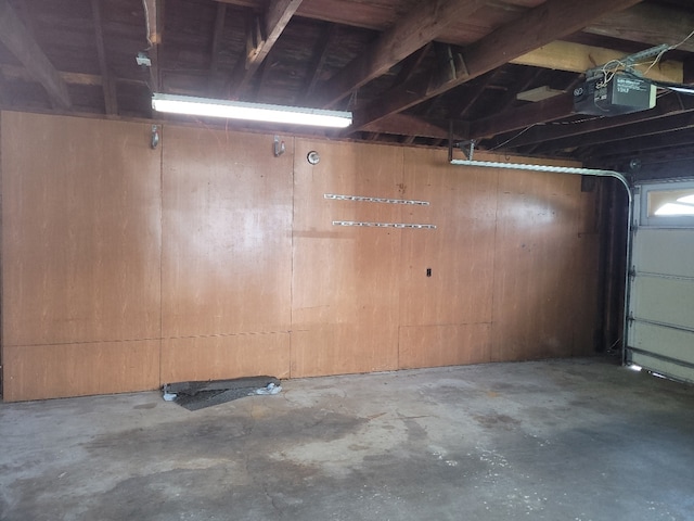 garage with a garage door opener and wooden walls