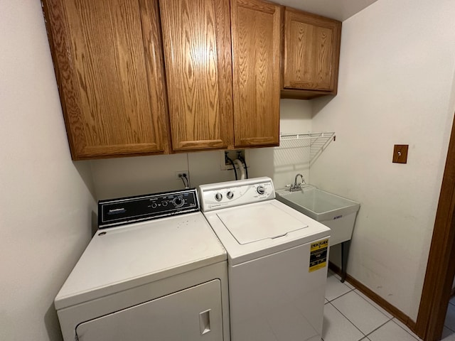 laundry area with separate washer and dryer, light tile patterned flooring, sink, and cabinets