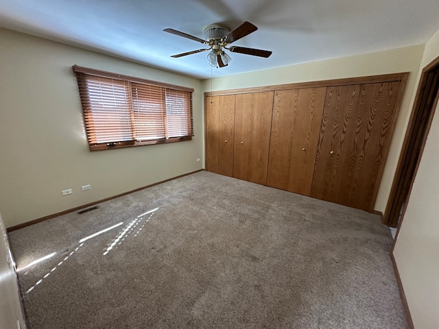 unfurnished bedroom with a closet, ceiling fan, and carpet floors