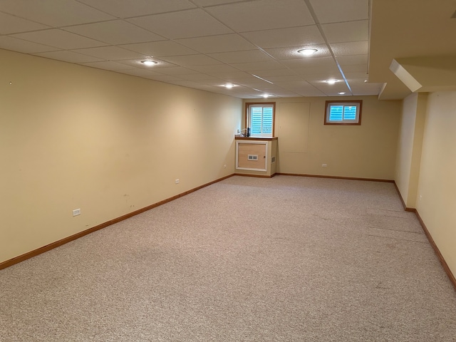 basement with a drop ceiling and light colored carpet