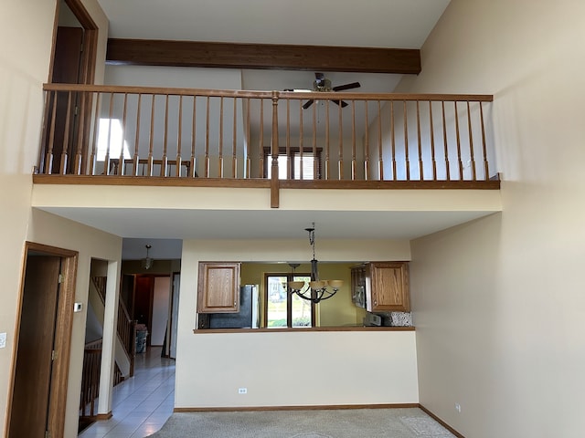 interior space featuring ceiling fan with notable chandelier and beam ceiling