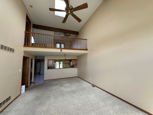 unfurnished living room featuring carpet floors, ceiling fan, and high vaulted ceiling