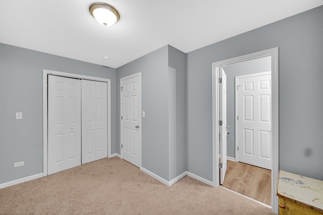 unfurnished bedroom featuring light colored carpet and a closet