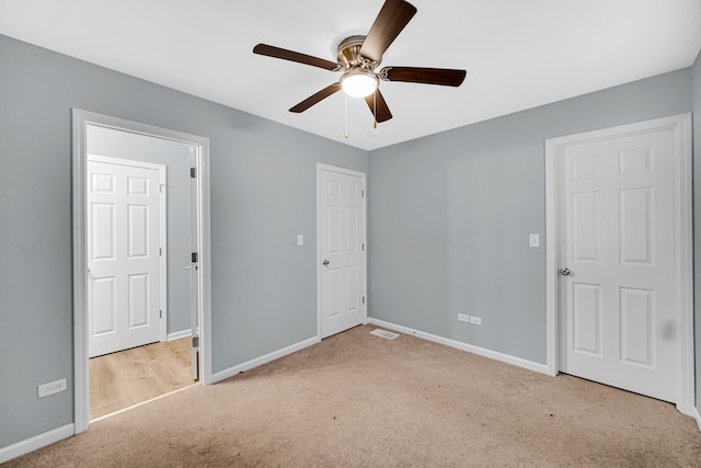 unfurnished bedroom with ceiling fan and light colored carpet