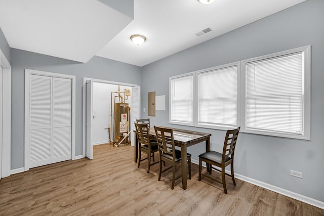 dining room featuring gas water heater, light hardwood / wood-style flooring, and a healthy amount of sunlight