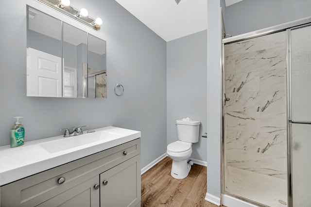 bathroom with vanity, wood-type flooring, a shower with shower door, and toilet