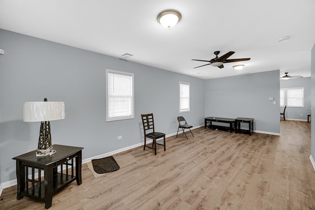 living area with ceiling fan, light hardwood / wood-style flooring, and plenty of natural light