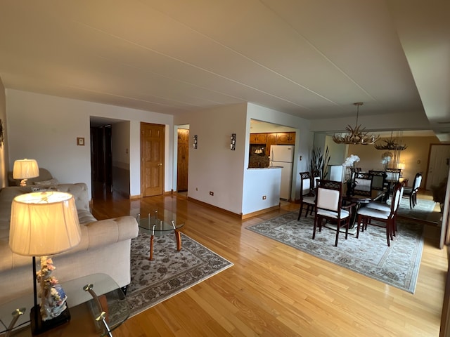 living room featuring a notable chandelier and light hardwood / wood-style floors