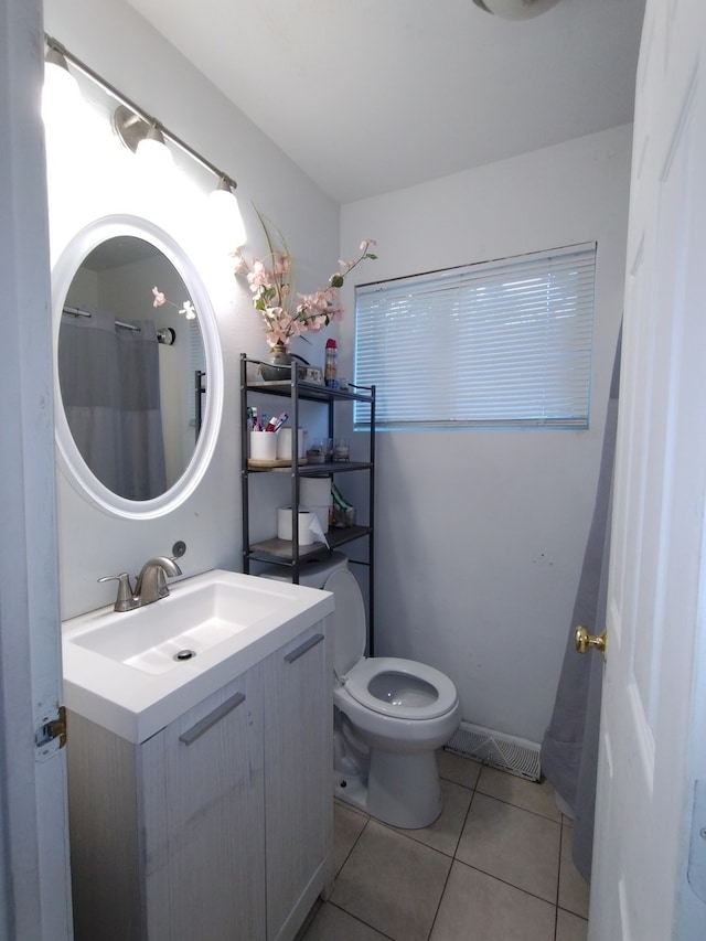 bathroom featuring walk in shower, vanity, toilet, and tile patterned floors