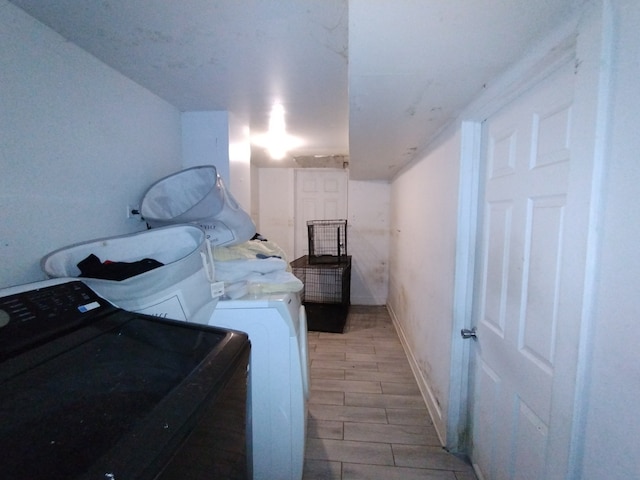 laundry area with washer and clothes dryer and light hardwood / wood-style flooring