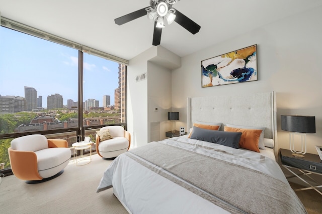 bedroom with ceiling fan and expansive windows