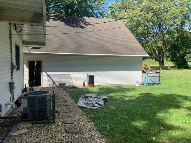 view of side of property featuring a yard and central air condition unit