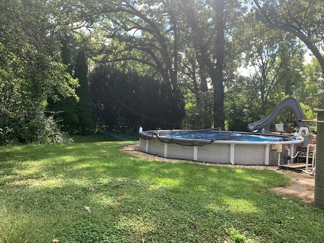 view of pool with a yard and a water slide