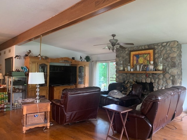 living room with wood-type flooring, beam ceiling, ceiling fan, and a fireplace