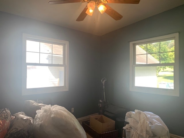 bedroom with ceiling fan and multiple windows