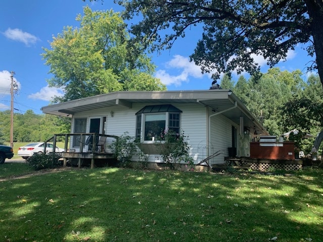 view of front of home with a deck and a front yard