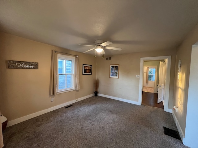 unfurnished bedroom featuring dark carpet and ceiling fan