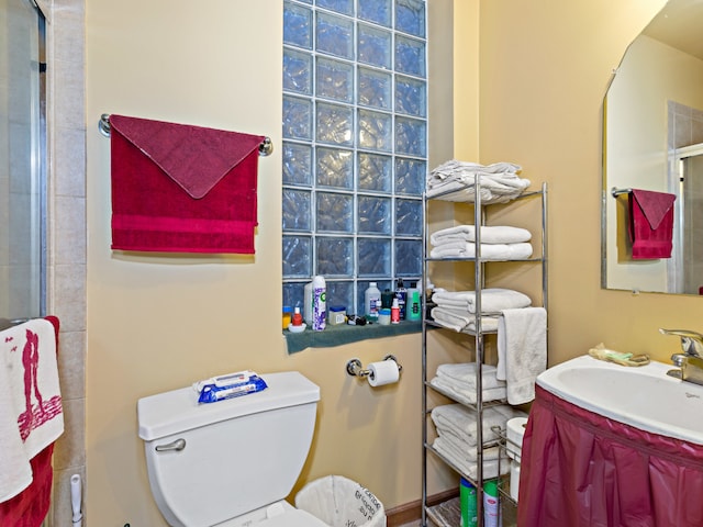 bathroom with a shower with door, vanity, and toilet