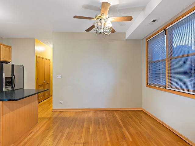 kitchen featuring ceiling fan, light brown cabinets, light wood-type flooring, and stainless steel fridge