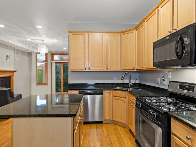 kitchen with stainless steel appliances, a chandelier, a kitchen island, and sink