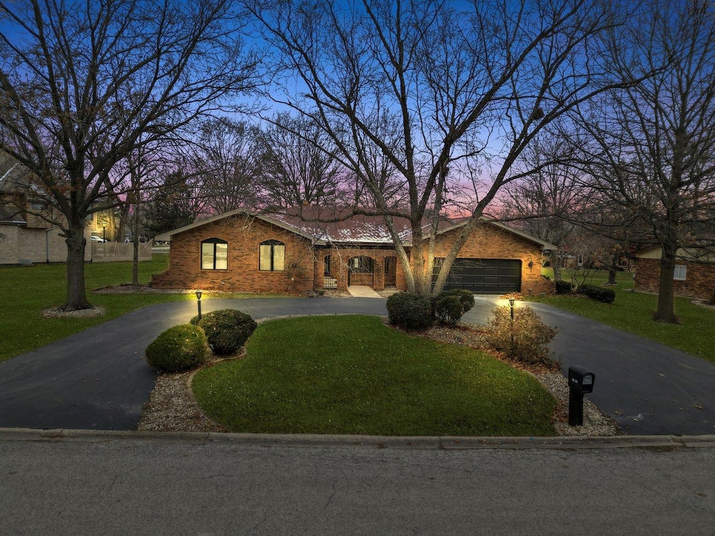 ranch-style house with a yard and a garage