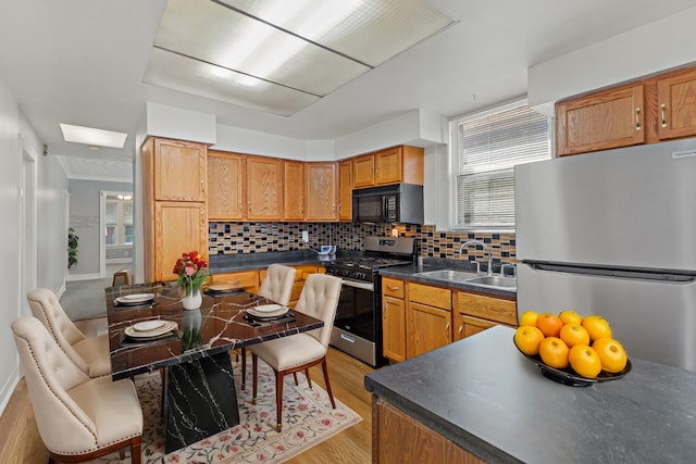 kitchen featuring light hardwood / wood-style flooring, stainless steel appliances, tasteful backsplash, and sink