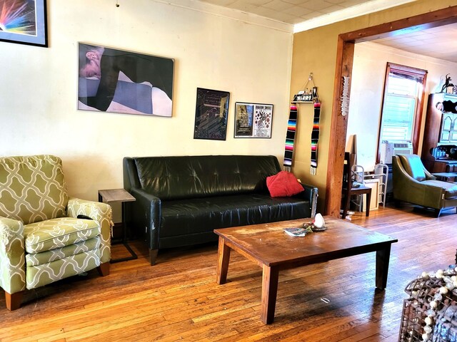 living room with hardwood / wood-style flooring and crown molding