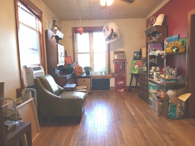 living room with cooling unit, dark wood-type flooring, ceiling fan, and a healthy amount of sunlight