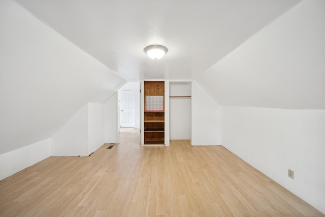 additional living space featuring vaulted ceiling and light hardwood / wood-style floors