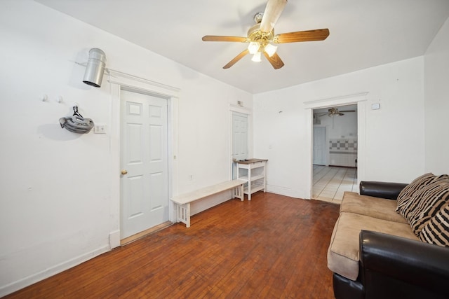 living room featuring dark wood-type flooring and ceiling fan